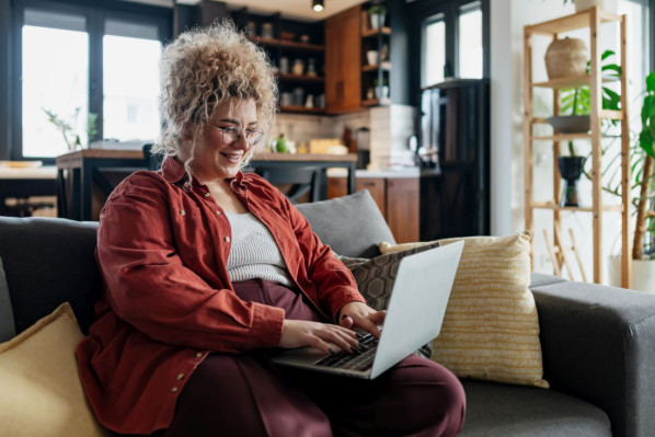 Eine übergewichtige Frau schaut sich mit Hilfe ihres Laptops den AOK Online-Coach Adipositas an.
