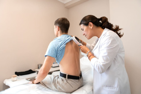 Dermatologin untersucht jungen Patienten