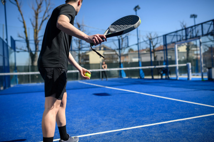 Ein Mann schlägt beim Padel auf