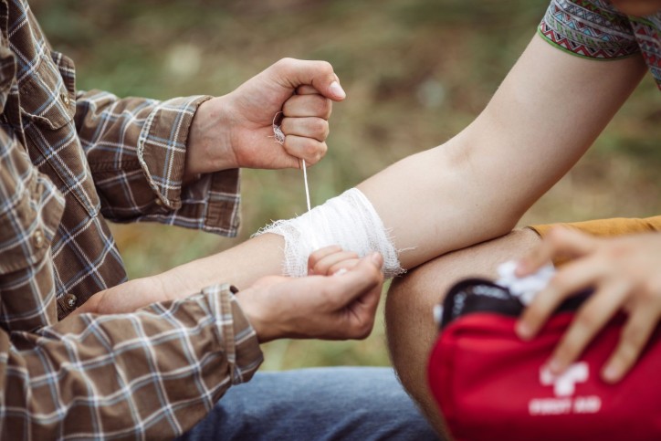 Eine Reiseapotheke liefert Verbandsmaterial um eine Armverletzung zu versorgen