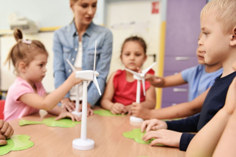 Kindergartenkinder lernen gemeinsam mit einer Erzieherinnen zum Thema Nachhaltigkeit.