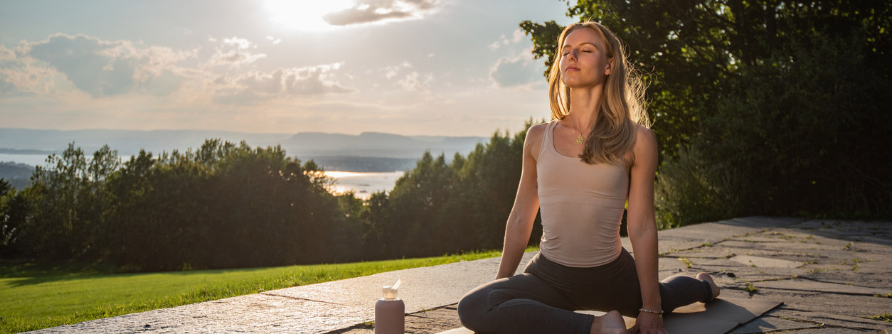 Eine Frau übt Yin Yoga bei Sonnenuntergang aus