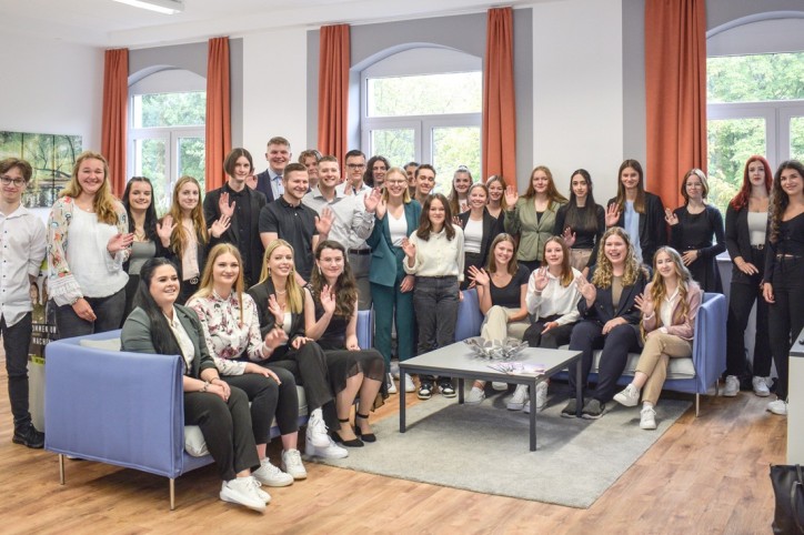 Zwei Auszubildende der AOK Sachsen-Anhalt siitzen gemeinsam im Park und machen ein Selfie.
