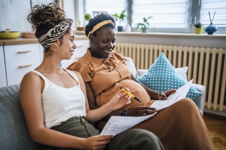 Zwei Frauen, von denen eine schwanger ist, planen die Geburt des Kindes