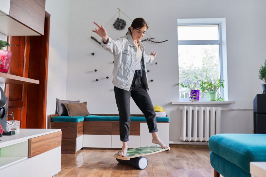 Junge Frau steht auf Balance Board