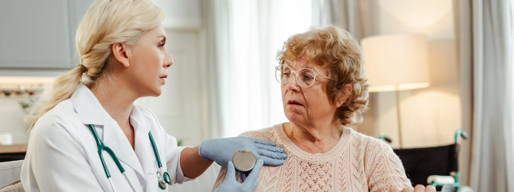 Eine Ärztin zeigt einer herzkerkrankten Seniorin einen ICD