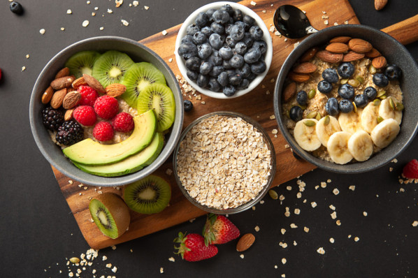 Müslischalen mit hafer, Beeren, kiwi und Nüssen