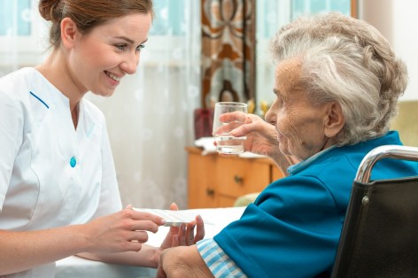 Pflegerin spricht mit Seniorin