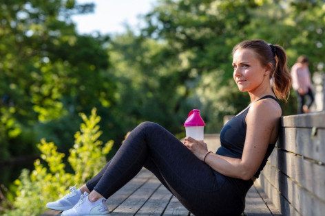 Junge Frau trinkt Proteinshake nach dem Sport