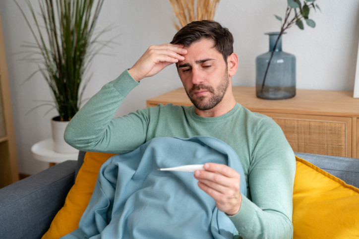 Ein Mann, der unter Hypochondrie leidet, misst Fieber