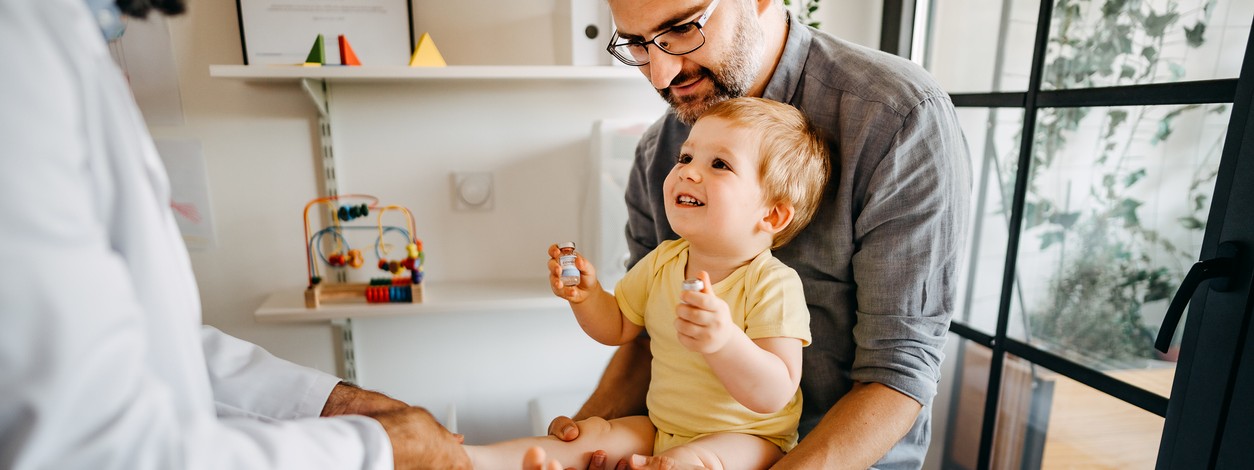 Kleinkind mit Vater beim Impfen beim Kinderarzt