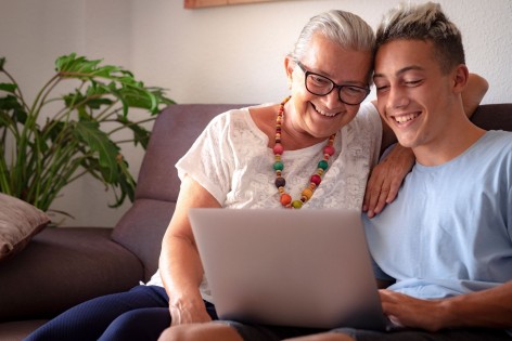 Enkel und Großmutter sitzen an einem Laptop