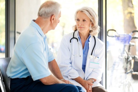 Eine Ärztin spricht mit einem männlichen Patientin.