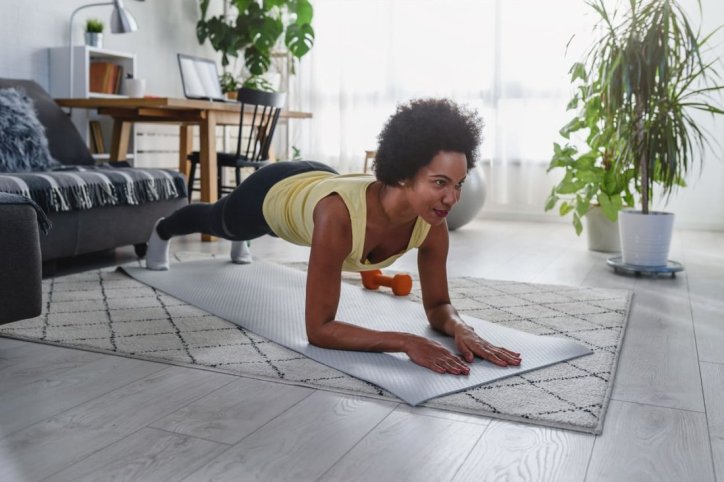 Frau führt funktionelles Training Zuhause durch
