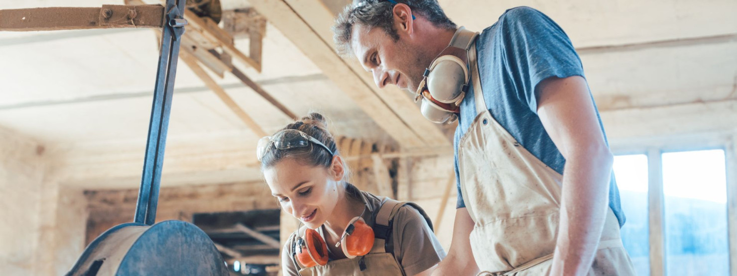 Zwei Beschäftigte arbeiten an einem Werkstück in der Werkstatt-