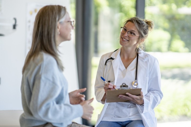 Eine Ärztin spricht mit einer Patientin und macht sich Notizen.