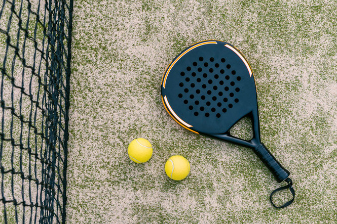 Ein Padel-Schläger mit zwei Bällen 