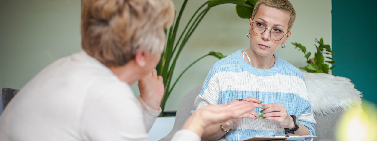 Eine Patientin spricht mit ihrer Psychologin, die ihr aufmerksam zuhört.