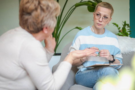 Eine Patientin spricht mit ihrer Psychologin, die ihr aufmerksam zuhört.