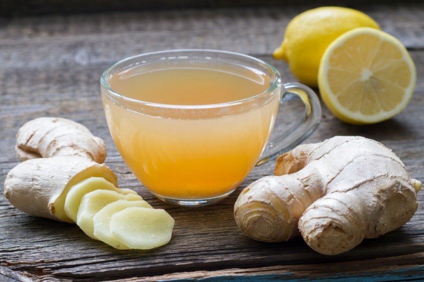 Ginger homemade tea infusion on wooden board with lemon still life