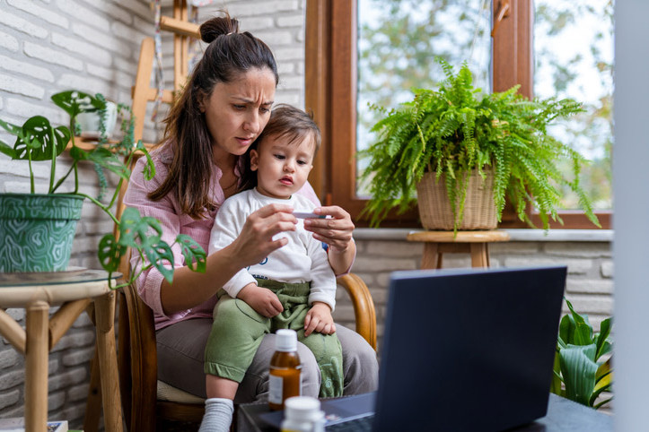 Eine Mutter misst Fieber bei ihrem an Pseudokrupp leidenden Sohn