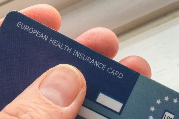 Mann hält Europäische Krankenversicherungskarte in der Hand. 