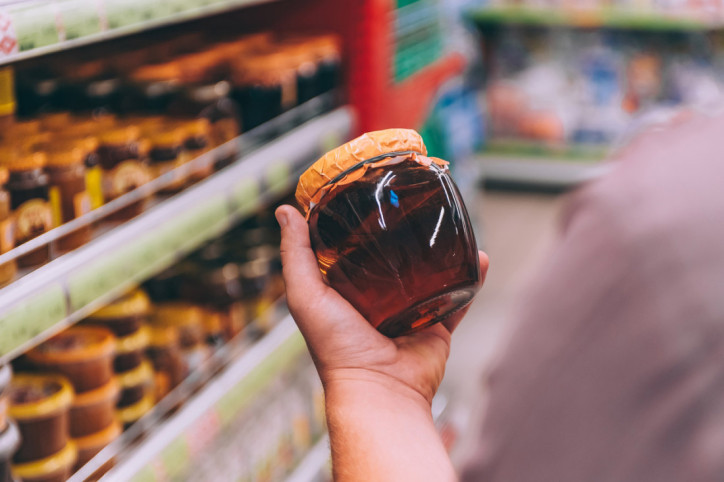 Ein prüfender Blick auf das Honigglas in einem Supermarkt