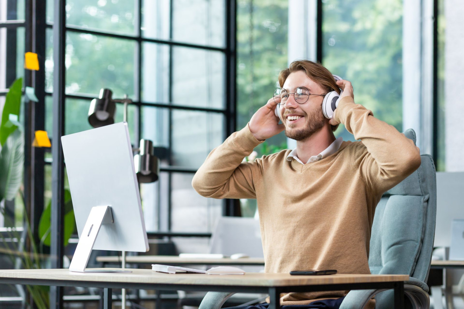 Ein Mann hört mit Kopfhörern den BGM-Podcast der AOK Sachsen-Anhalt