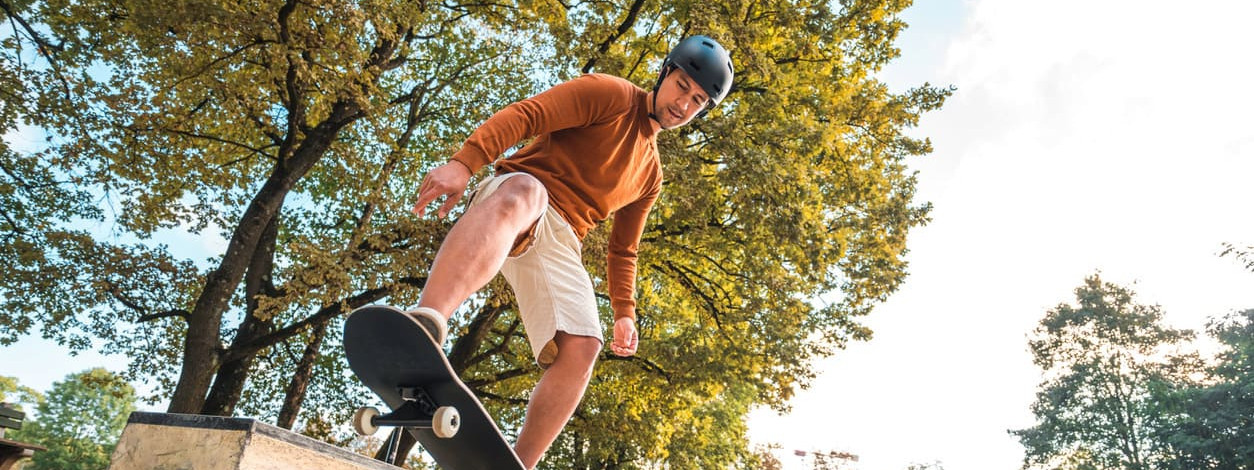 Ein Mann versucht sich an einem Manual auf dem Skateboard