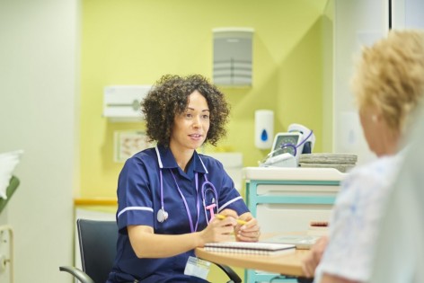 Eine Krankenschwester im Gespräch mit einer Patientin.