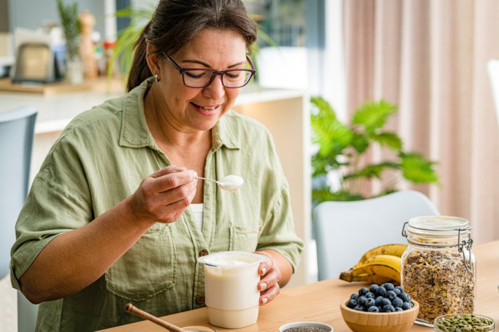 Eine Frau stärkt ihr Mikrobiom durch Naturjoghurt