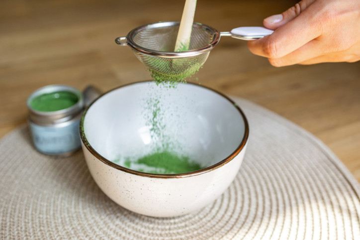 Matcha-Pulver wird durch ein Sieb gefiltert