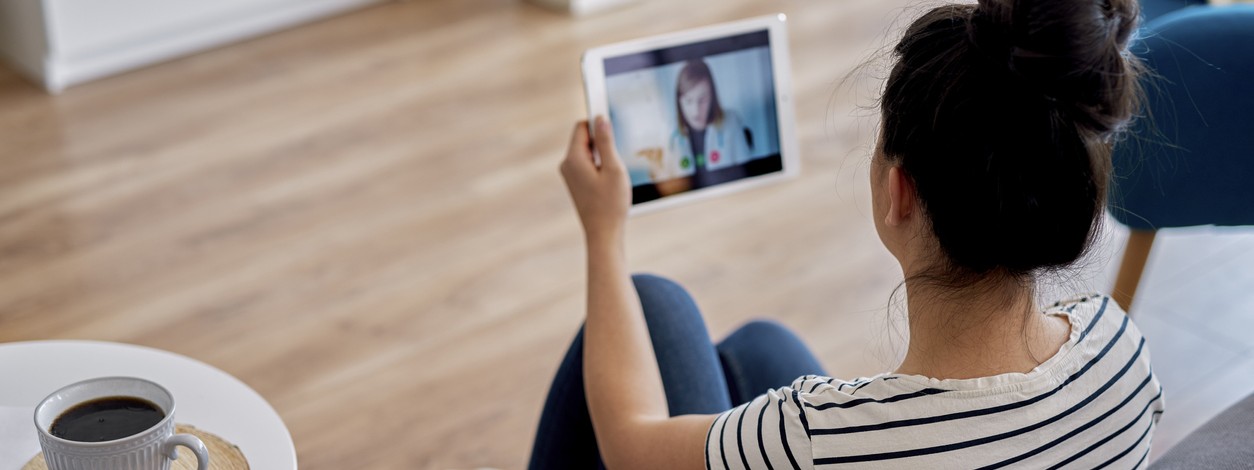 Eine Frau spricht über ein Tablet mit einer Ärztin.