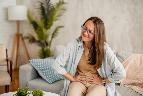 Eine Frau leidet aufgrund einer Nahrungsmittelallergie unter Bauchschmerzen
