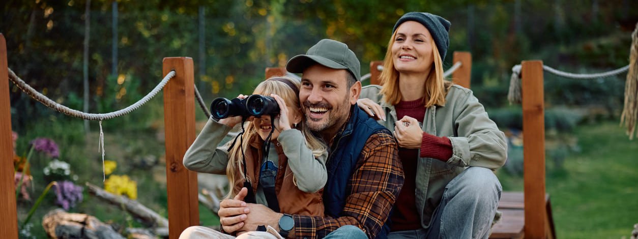 Glückliche Familie beobachtet die Natur von einem Steg aus