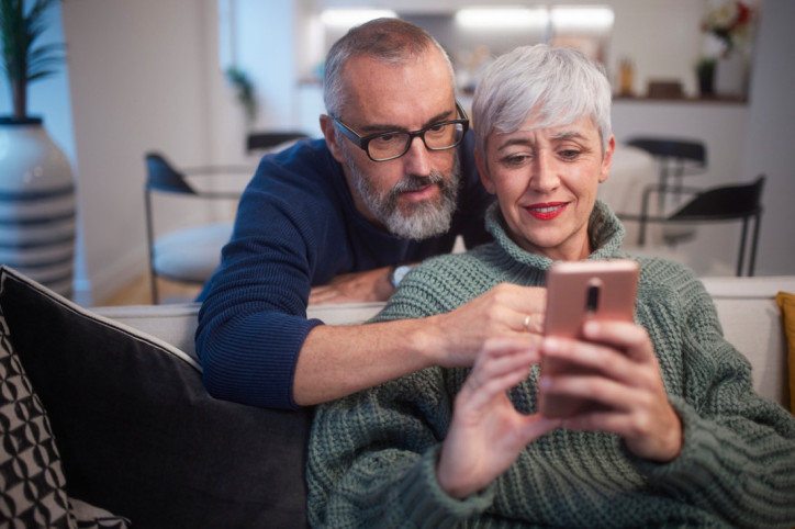 Ein älteres Paar freut sich über das telefonische Beratungsangebot zum Thema Krebs
