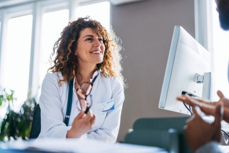 lächelnde Ärztin im gespräch mit patient