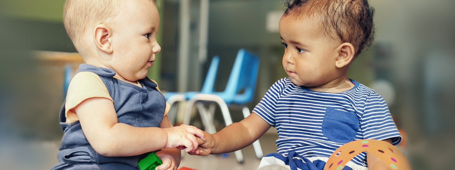 Zwei Babies spielen zusammen mit bunten Bausteinen