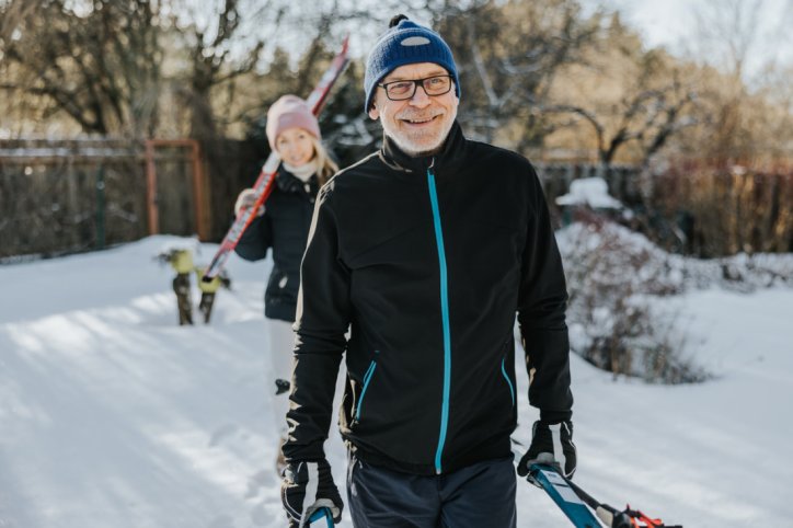Vater und erwachsene Tochter auf dem Weg zum Langlauf