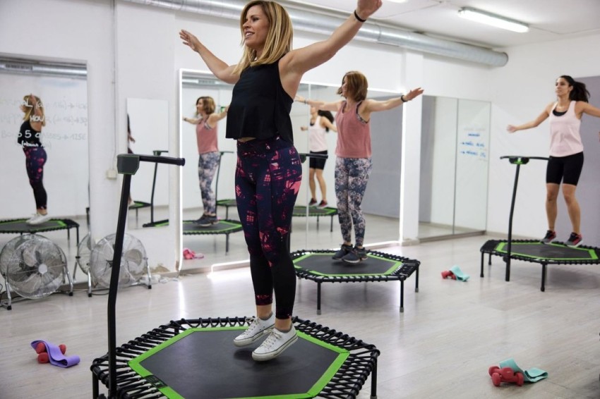 Mini trampoline fitness class. General view of the whole class with the instructor in the foreground.