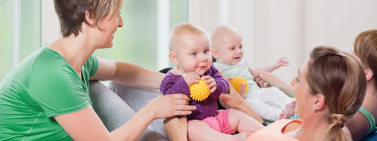 Babys und ihre Mütter nehmen an einem Babykurs teil