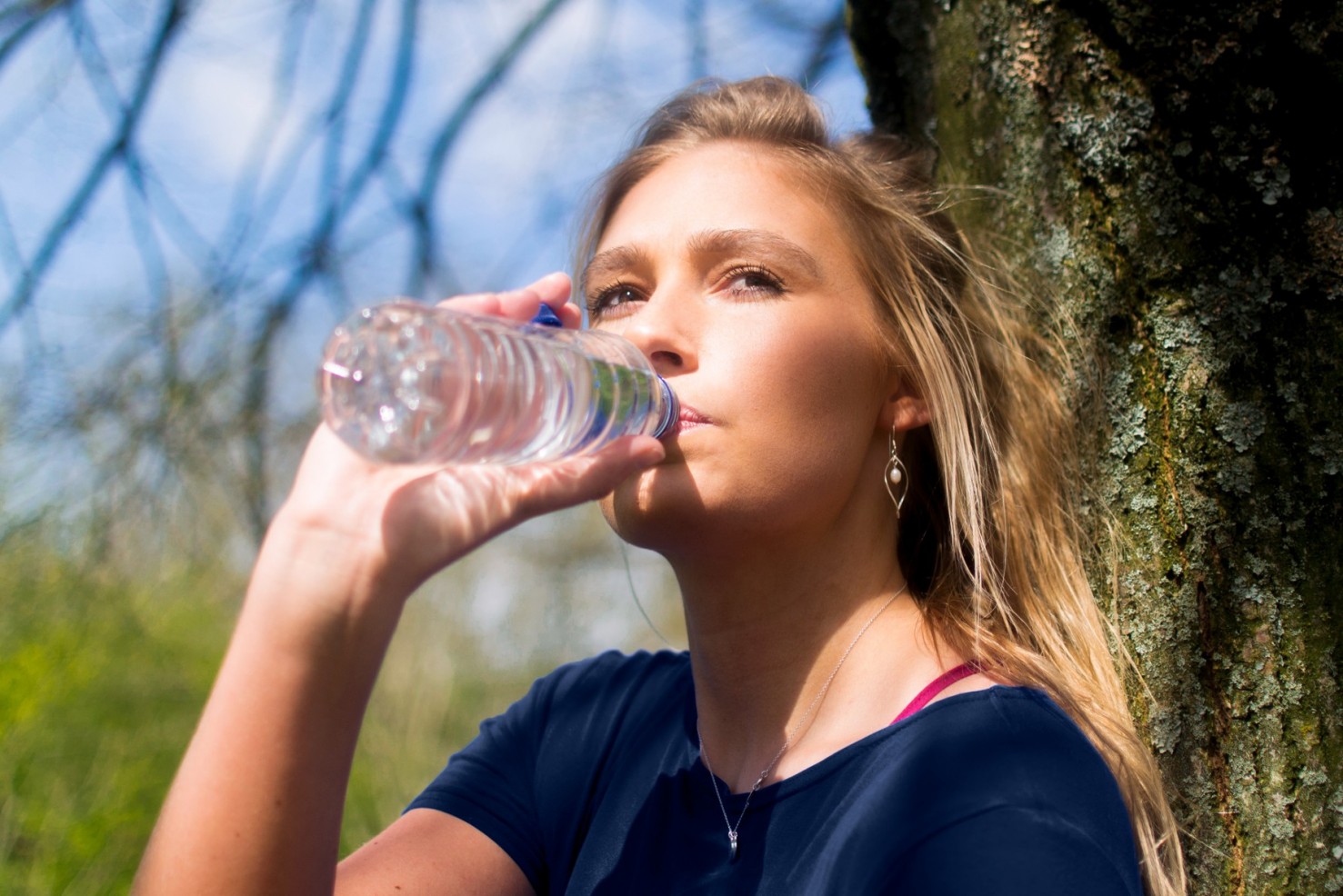 Junge Frau trinkt einen Schluck Wasser