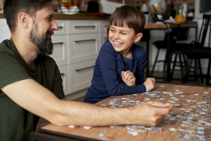 Ein Vater und sein Sohn aktivieren ihr Gehirn beim gemeinsamen Puzzlen