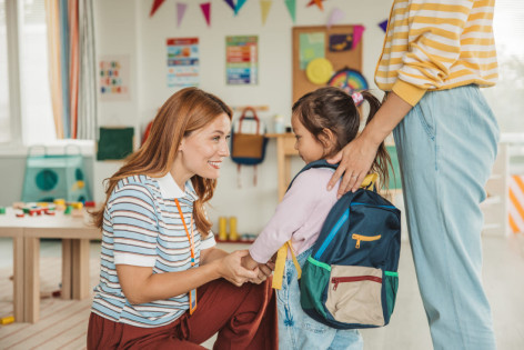 Eine Mutter bringt ihre kleine Tochter in die Kita