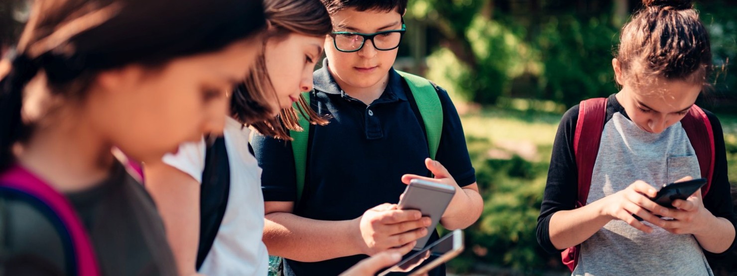 Schüler schauen gebannt auf ihre Smartphones.