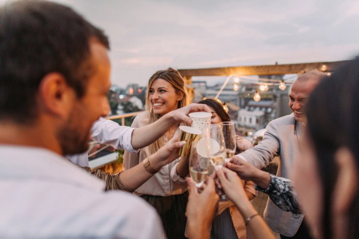 Bei einer Party auf einer Dachterrasse wird angestoßen