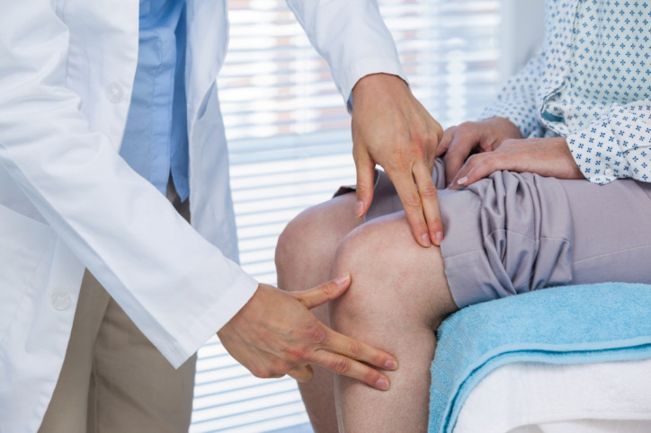 Ärztin untersucht Knie