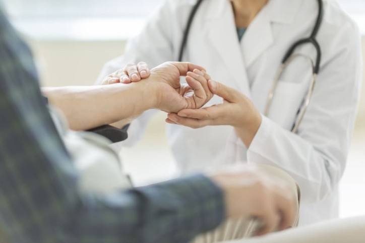 Ein Arzt prüft geht einem Verdacht auf Ringelflechte bei einem Patienten nach