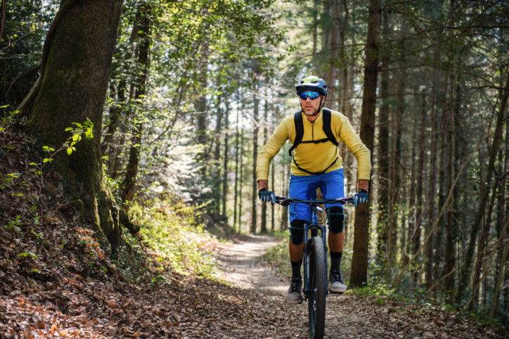 Ein Mountainbiker fährt über einen Waldweg