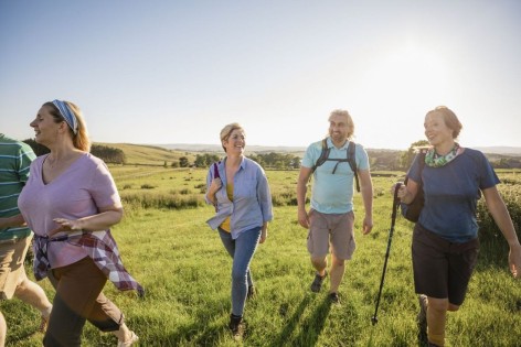 Zwei Frauen und ein Mann mittleren Alters beteiligen sich am Wandern mit Herzblut